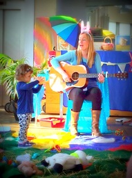Una singing with guitar and toddler dancing